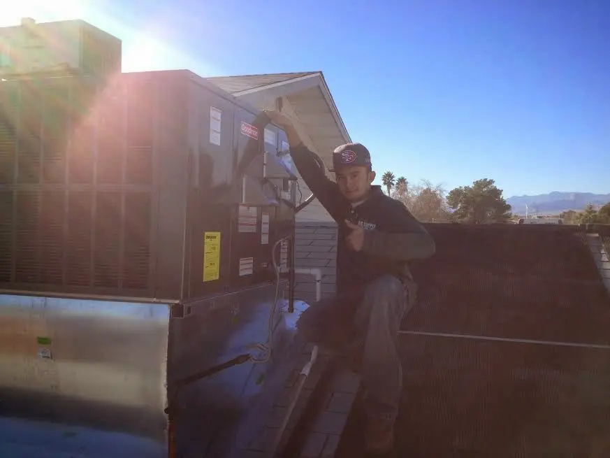 HVAC technician performing HVAC Inspection on a rooftop unit in Indian Hills